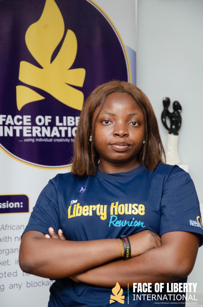 A fellowship alumna standing before the Face of Liberty International banner